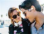 Young couple standing together, outdoors, smiling