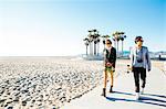 Young couple walking along beach walkway