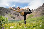 Woman practising yoga on meadow, Cathedral Lake, Aspen, Colorado