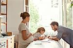 Pregnant mother watching as daughter spends quality time with father