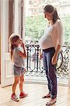 Mother preparing daughter for arrival of her new sibling