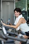 Woman exercising in fitness club with water bottle in hand