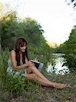 USA, Utah, Provo, woman sitting by lake doing notes