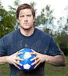 USA, Utah, Provo, Portrait of young man holding football