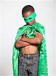Studio shot of boy (6-7) wearing green cape and green mask