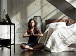 Woman practicing yoga on bedroom floor