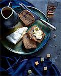 Overhead view of date and walnut loaf slice with fresh brie