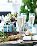 Close up of table of champagne with xmas crackers and gifts