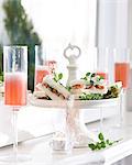 Champagne flutes of pink champagne and crayfish sandwiches on cake stand