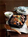 Middle eastern oxtail stew in serving dish with wooden serving spoon