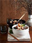 Seafood laksa in stacked bowl on whitewashed cutting board