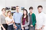 Colleagues side by side in office looking at camera smiling