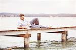 Mature man relaxing on pier