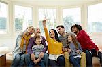 Multi generation family on window seat  using smartphone to take selfie