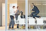 Exuberant businessman gesturing with fists on top of conference table