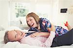 Well-dressed mature couple laughing on bed