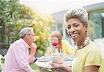 Portrait smiling mature woman enjoying lunch with friends in garden