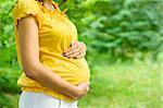 Beautiful pregnant woman outside in the park