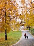 Mother with child walking through autumn park