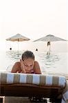 Teenage girl sunbathing on lounge chair