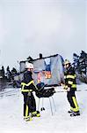 Firefighters having barbeque in front of burning house