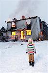 Alone girl standing in front of burning house