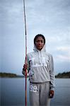 Young woman with fishing rod at evening