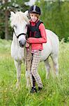 Girl with pony on meadow