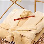 Folded Robe with Soap and Toothbrush on Wicker Chair