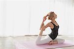 Attractive young Japanese practicing yoga in an airy room