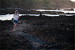 Woman running on rocky beach