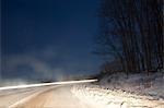 Long exposure of car on snowy rural road
