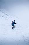 Hiker snow shoeing in rural landscape