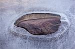 Hole in layer of ice on rural lake