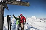 Hikers posing on snowy mountaintop