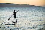 Woman paddleboarding on ocean