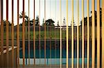 View of swimming pool through window blinds