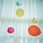 Colourful balloons against white curtain