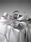 Still life with parcel wrapped in silver paper and ribbons