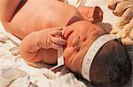Newborn baby girl with tape measure around head