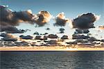 Blue sea and sunlit clouds at sunrise