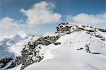 Mid adult male skier walking to top of mountain with skis, Corvatsch, Switzerland