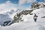 Mid adult male skier walking along top of mountain with skis, Corvatsch, Switzerland