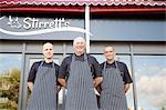 Portrait of three male butchers outside butchers shop