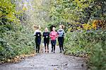 Teenage girl and women runners running in park