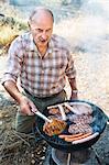 Man preparing meat on barbecue