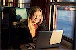 Young woman with laptop in train