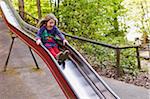 5 year old girl having fun on a slide at a playground, Germany