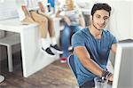 Portrait confident creative young businessman working at computer