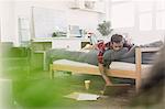 Young man laying on bed using laptop in apartment